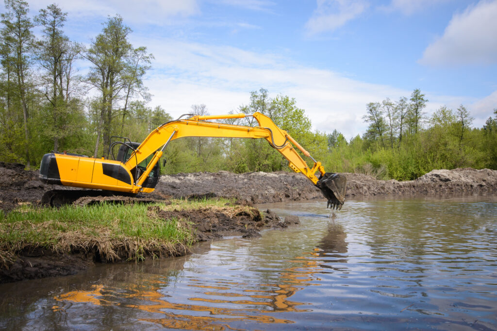 Excavator Working on Dredging a Pond