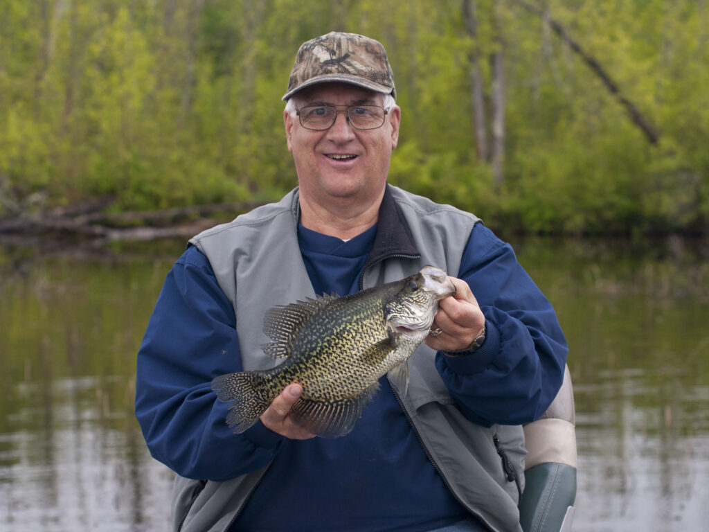 angler holding black crappie fish